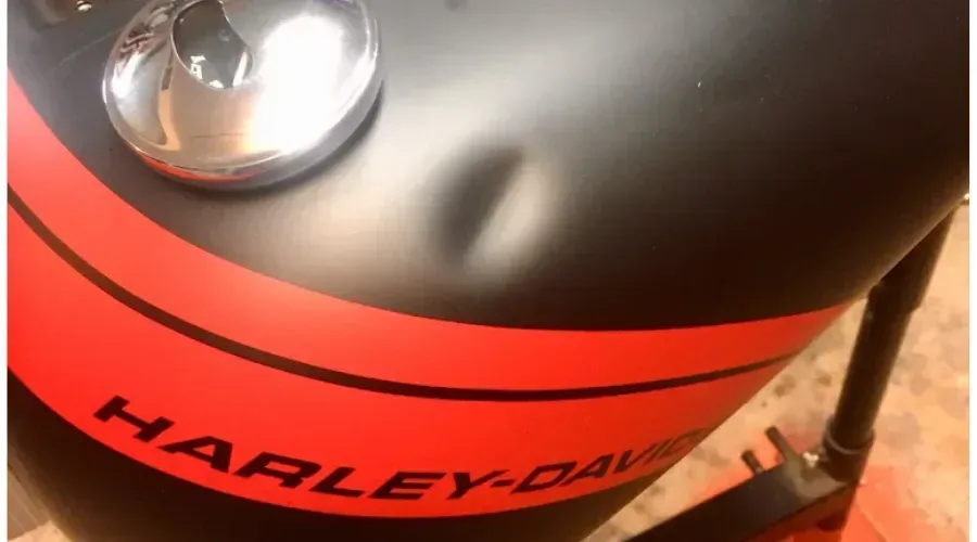 Close-up of a black and red Harley-Davidson motorcycle tank with chrome gas cap