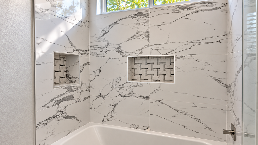 White marble-tile shower with two built-in niches and a frosted window above the tub
