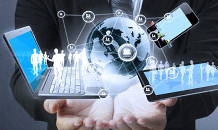 Hands holding globe, laptop, tablet, and smartphone connected by network, showing silhouettes of people on devices