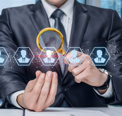 Businessman examining digital profiles through a magnifying glass, recruiting concept.