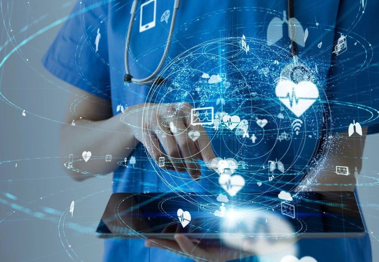 Doctor in blue scrubs uses tablet, overlaid with glowing healthcare icons.