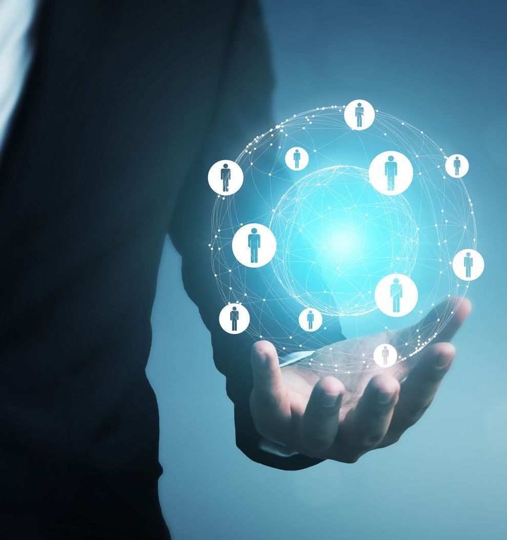 Person holding glowing digital sphere with connected human silhouettes.