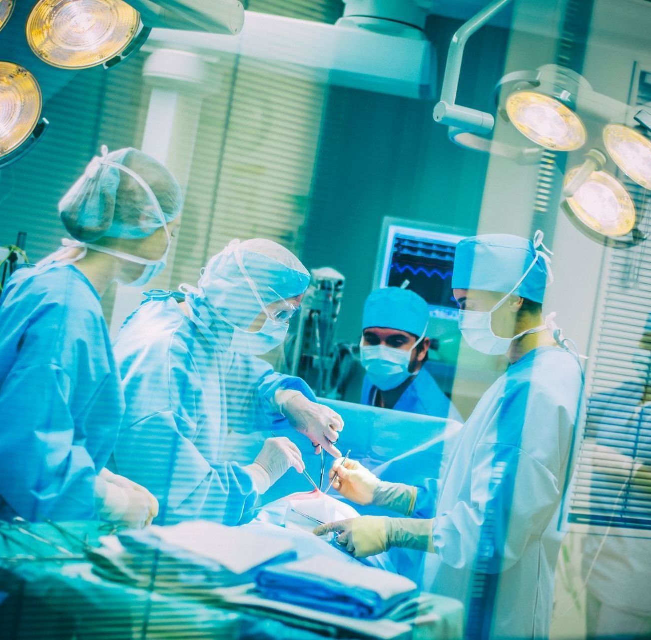 Medical team performing surgery under bright lights.