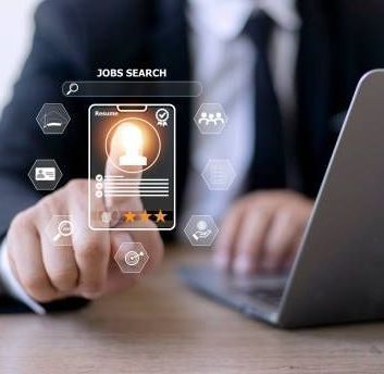 Person in a suit using a laptop, searching for a job online; futuristic interface showing resume and icons.