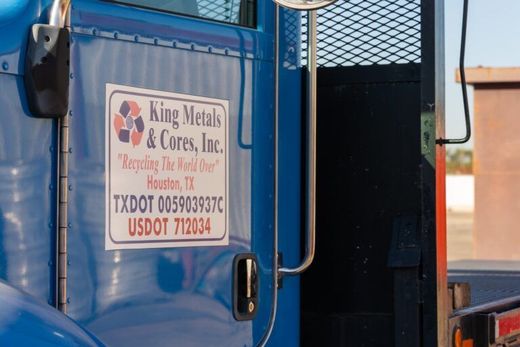 Blue truck cab with a King Metals sign and USDOT number on the door