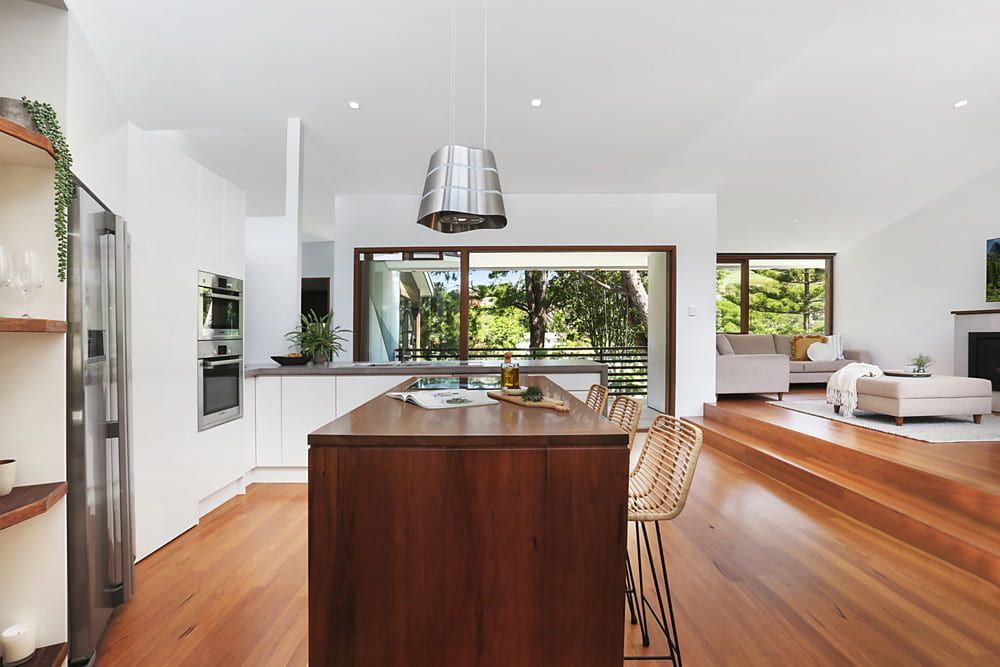 Modern Kitchen With Wood Island, Light Wood Floors, and View of Trees  — Envisage Construction and Design in Koloona Dr, NSW
