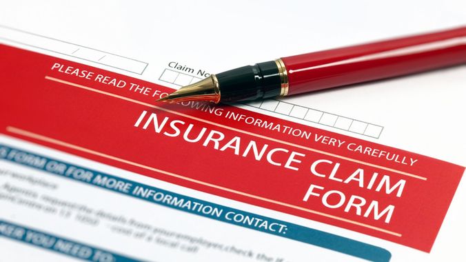 A pen is sitting on top of an insurance claim form.