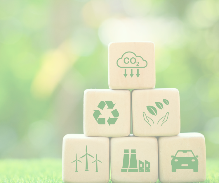Eco-themed wooden blocks with recycling, CO2, wind turbines, factory, leaves, and electric car icons
