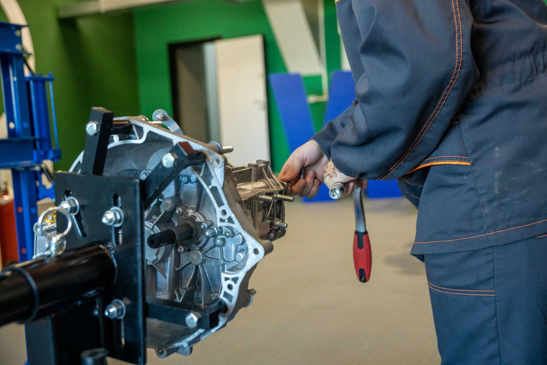 Mechanic using a wrench to work on a car engine in a workshop