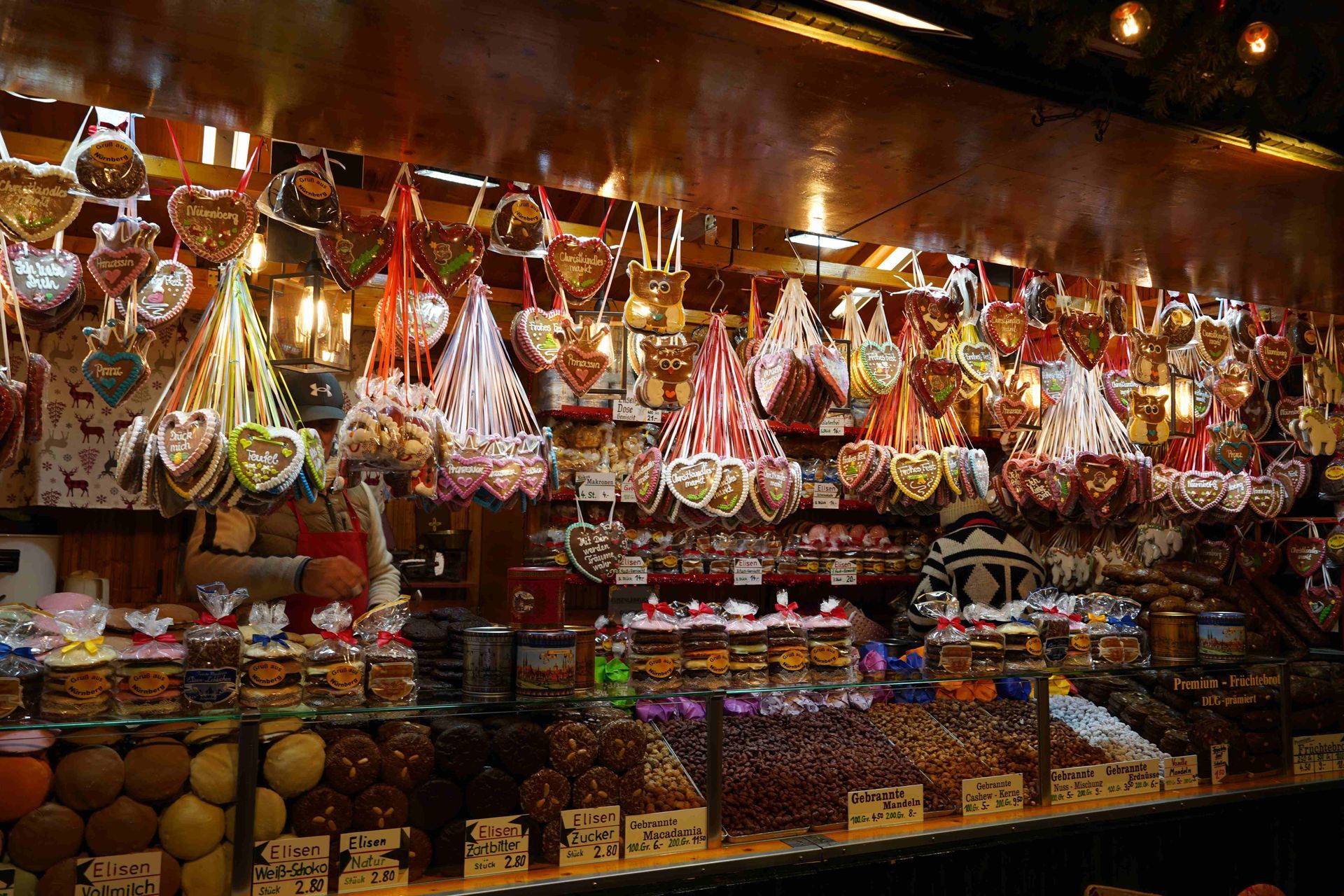 A colorful market stall filled with sweets, candies, and hanging treats under warm lights