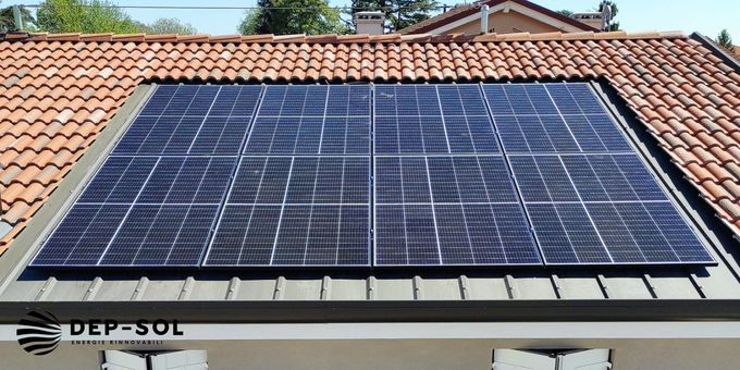 Pannelli solari installati su un tetto di tegole sotto un cielo sereno.