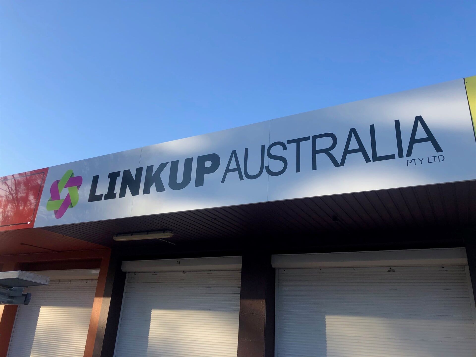 A Sign on the Side of a Building That Says Linkup Australia — Bluey's Signs in Ciccone, NT