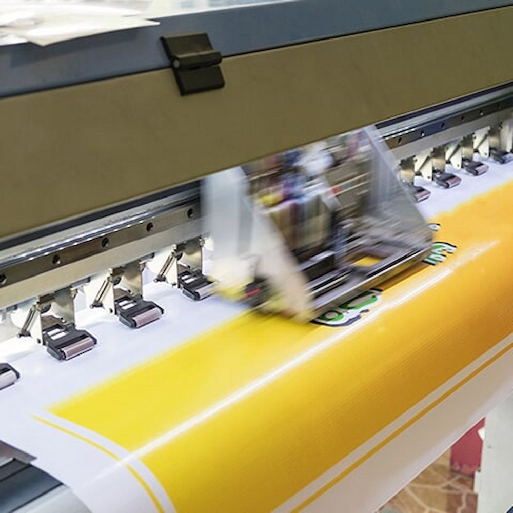 A Printer is Printing a Large Yellow and White Sheet of Paper — Bluey's Signs in Ciccone, NT A Printer is Printing a Large Yellow and White Sheet of Paper — Bluey's Signs in Ciccone, NT