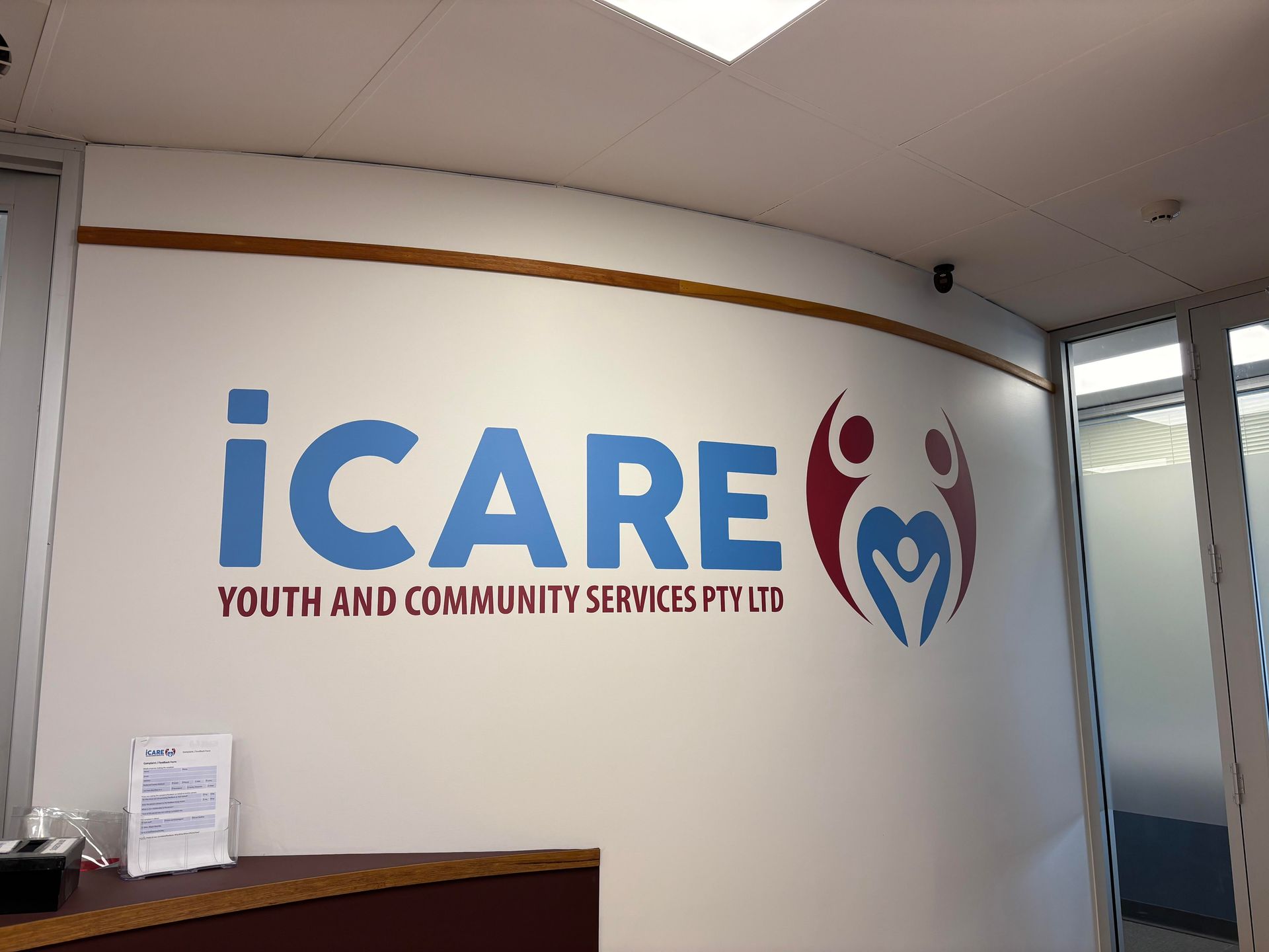 A Sign on a Wall That Says Icare Youth and Community Services Pty Ltd — Bluey's Signs in Ciccone, NT