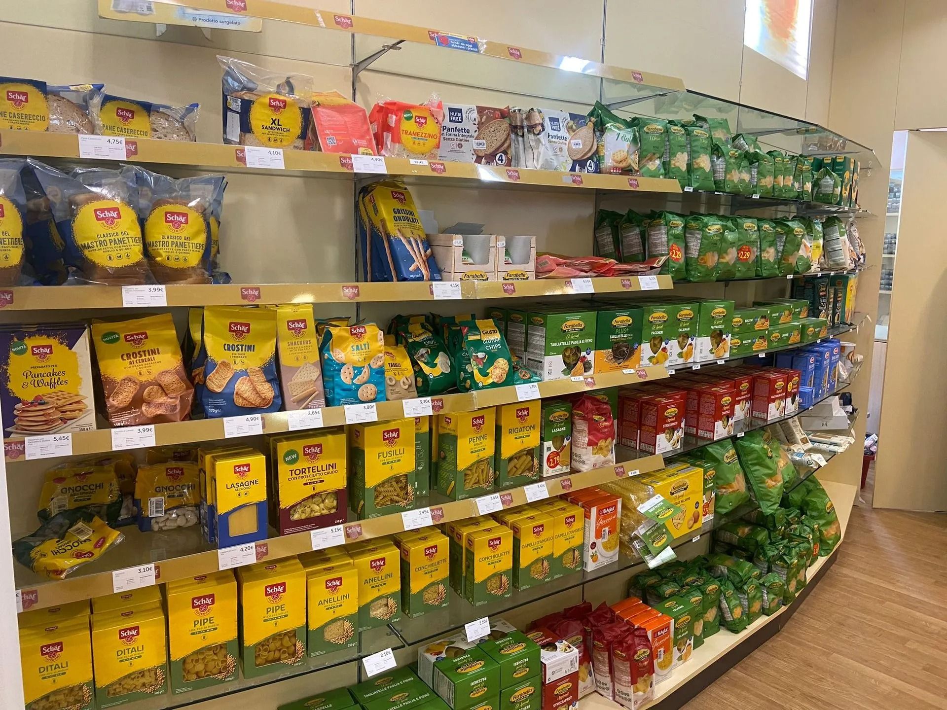 Corridoio degli snack di un supermercato con scaffali pieni di patatine e snack confezionati in modo colorato.