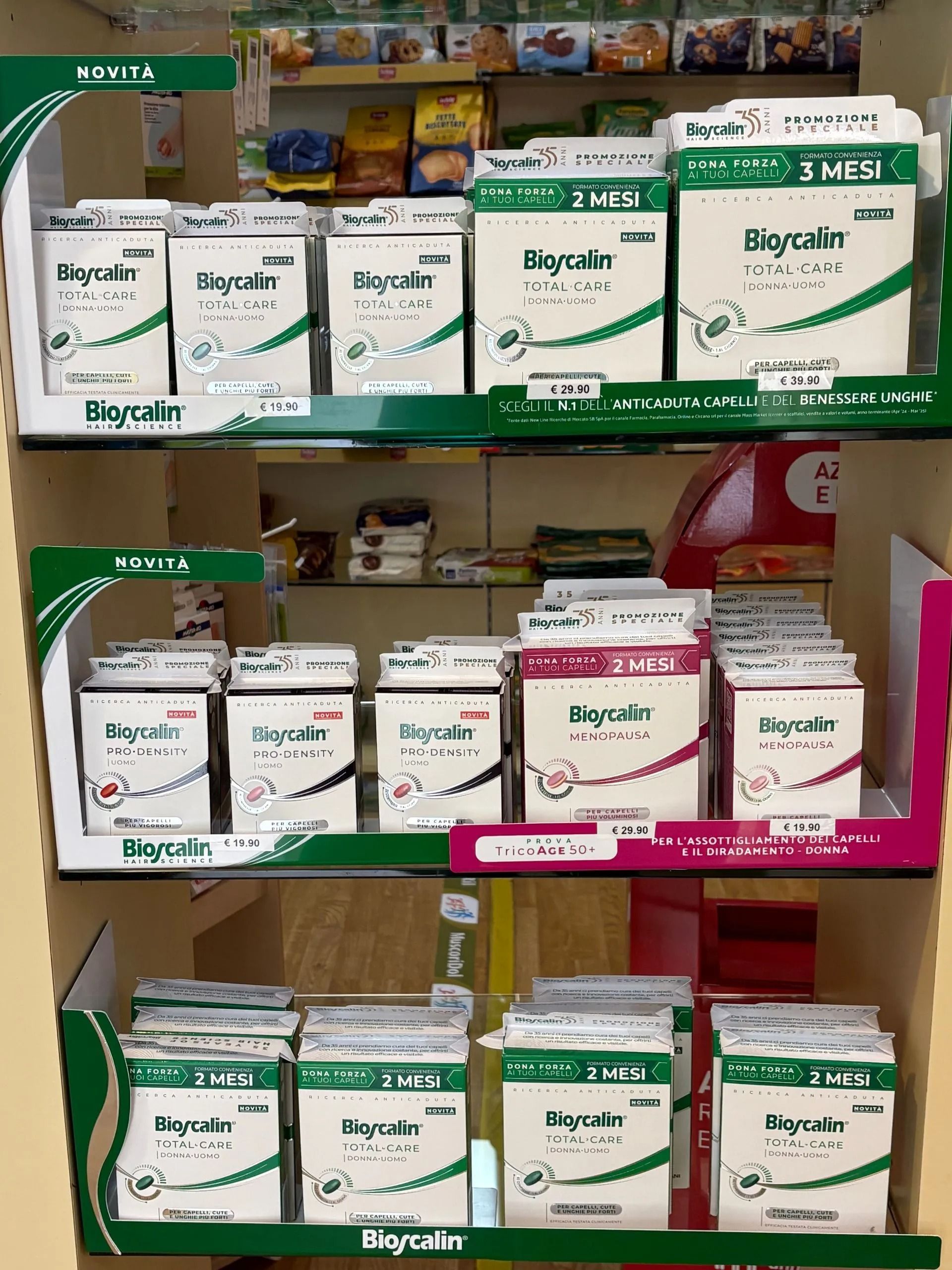 Scaffali pieni di scatole verdi e bianche contenenti forniture mediche in una corsia di un negozio.