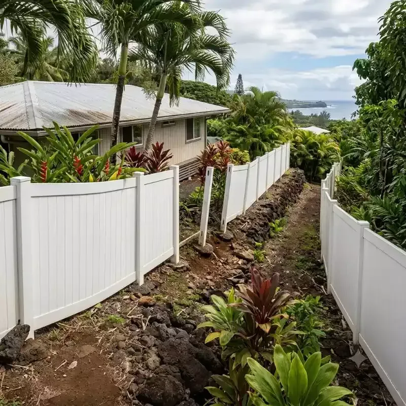 White fencing on a tropical coastal slope.