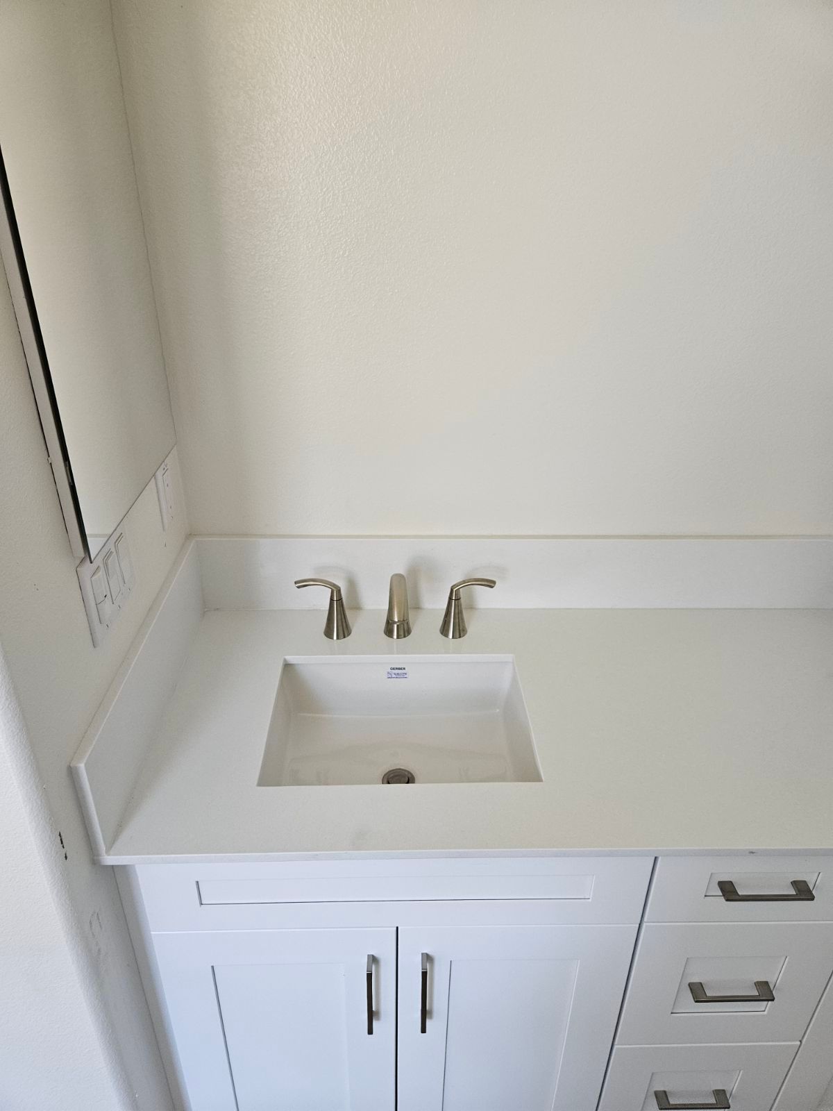 Bathroom vanity with white sink, chrome faucet, mirror, and built-in drawers underneath