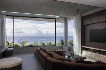 Modern living room with ocean-view windows, sectional sofa, and neutral decor.