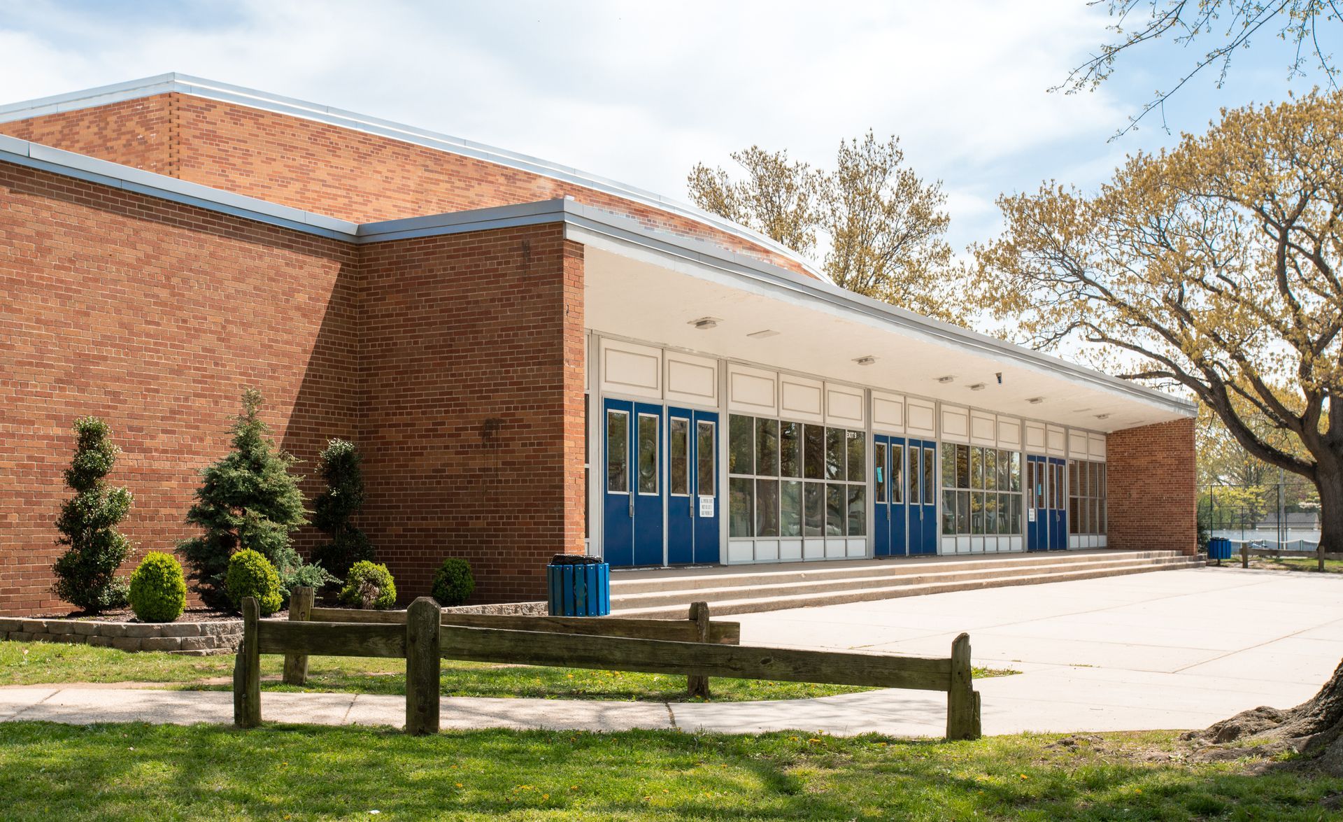 Brick building with blue doors and windows, seen from the front on a sunny day Brick building with blue doors and windows, seen from the front on a sunny day