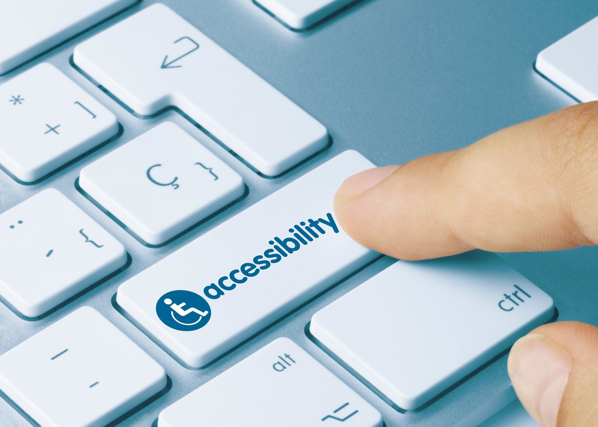Finger pressing accessibility key on white keyboard