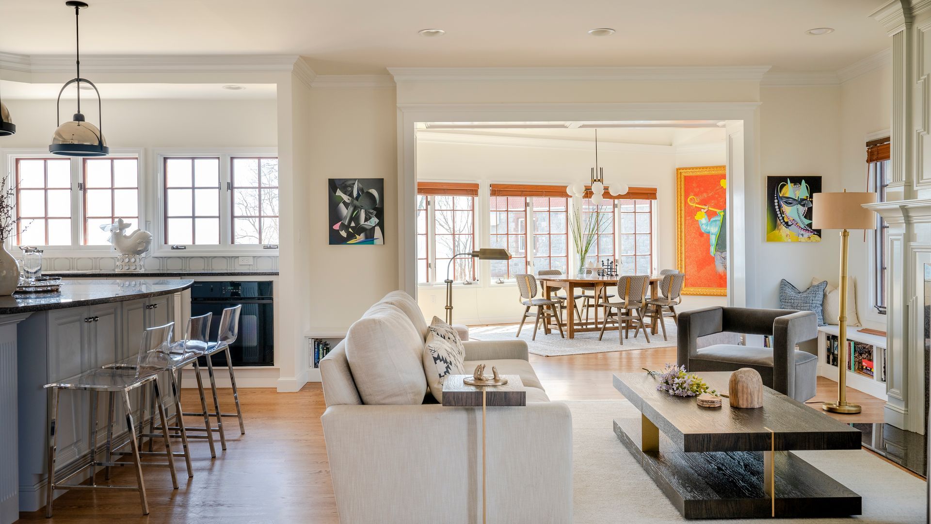 Bright open-concept living room with kitchen, dining area, and large windows