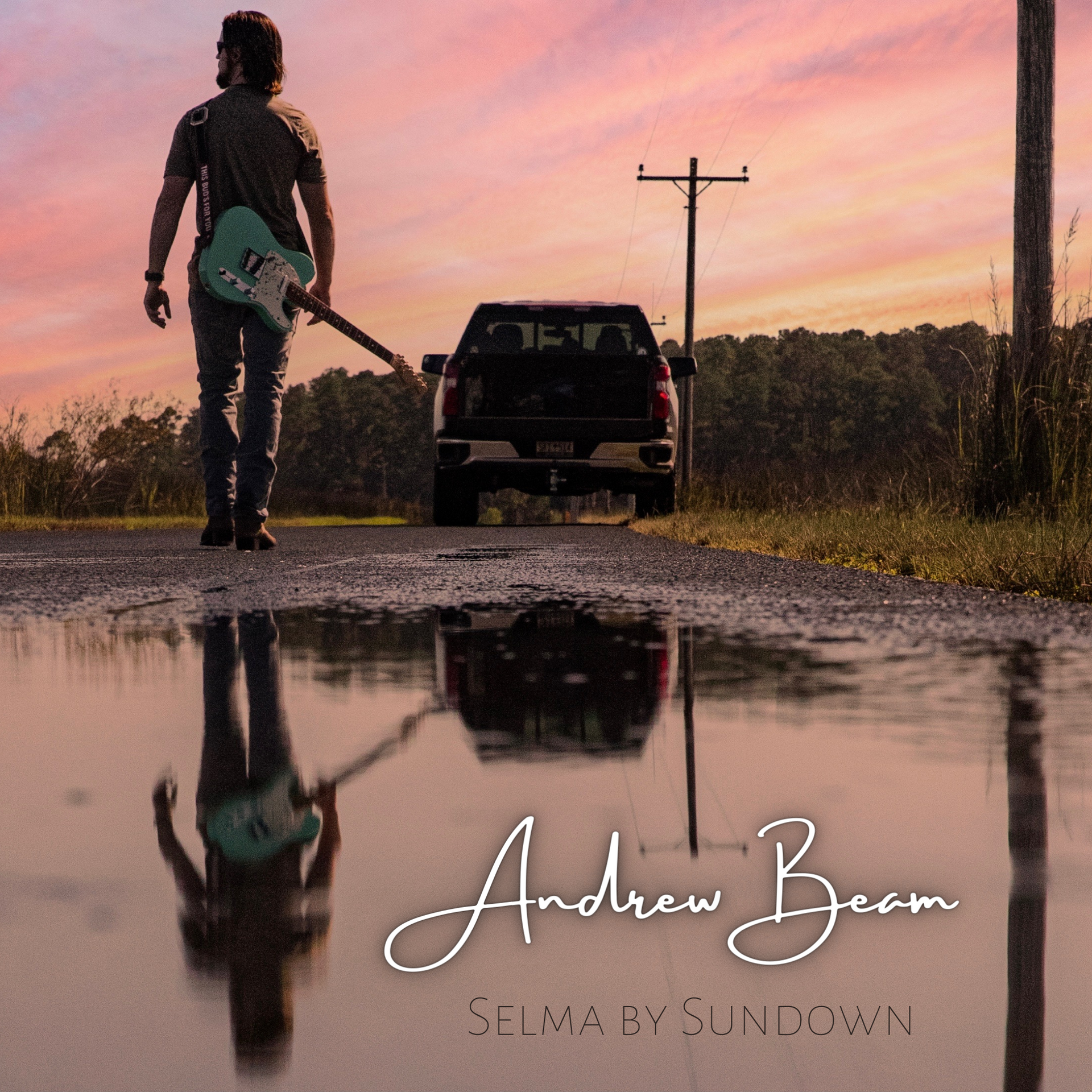 A man walking down a road with a guitar in his hand