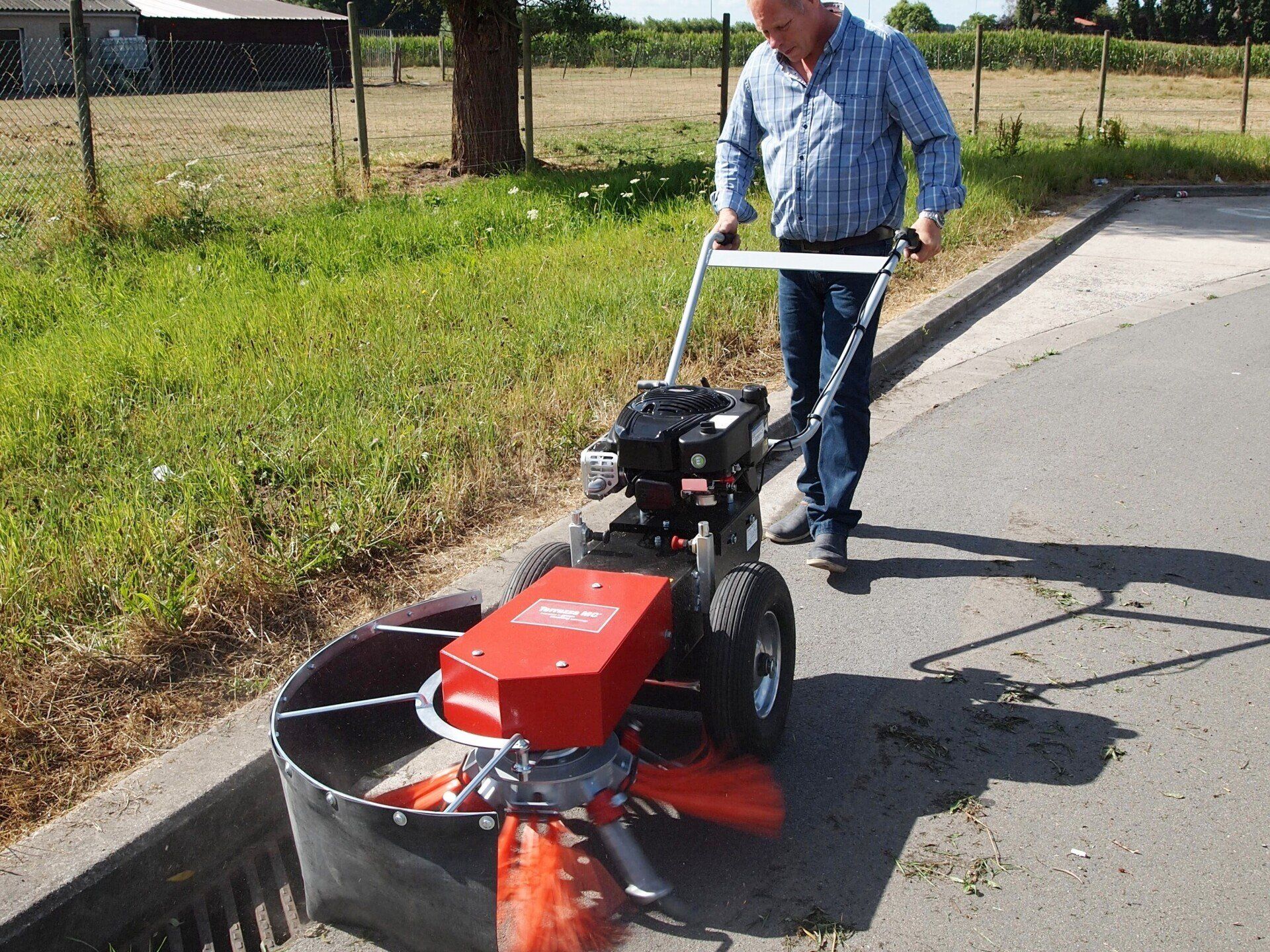 A man using the Weedee PRO® on a road to remove weeds and mosses.