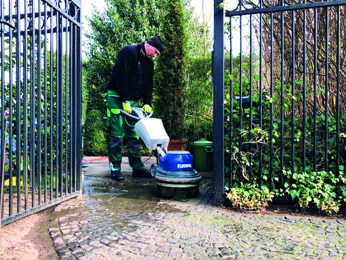 A man using the TMC® Kit on a cobblestone driveway.