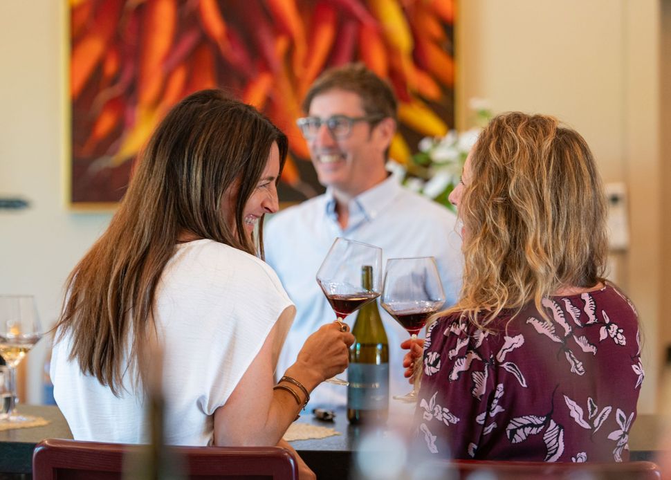 Friends sharing Brashley wine and conversation in the tasting room