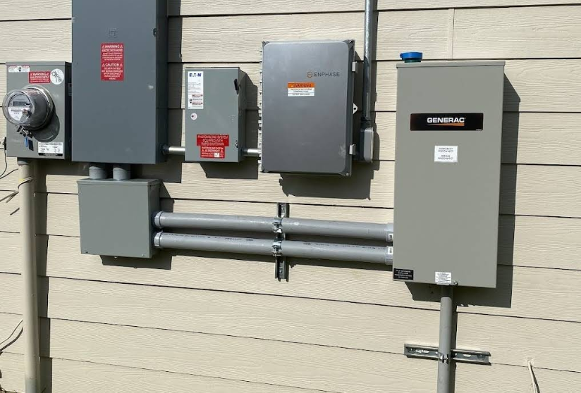 Electrical utility boxes and conduit mounted on a beige building wall.
