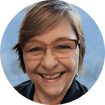 Woman with short brown hair and glasses smiles.