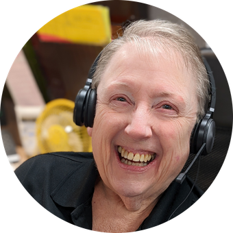 Person with a headset smiling brightly. Indoor setting.