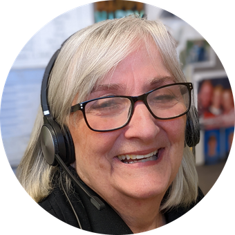 Woman with glasses and headset smiles.