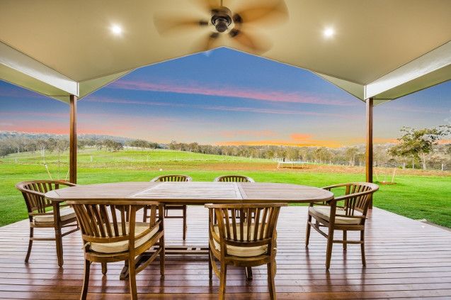 A Wooden Deck With a Bench and Trees in the Background — Peter Betros Homes in Highfields, QLD