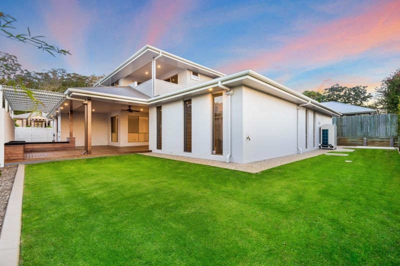 A Large White House with A Large Lawn in Front of It — Peter Betros Homes in Highfields, QLD