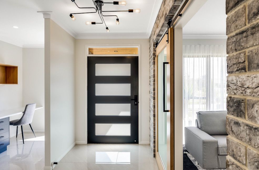 A Hallway in A House with A Black Door and A Couch — Peter Betros Homes in Highfields, QLD