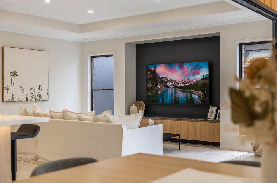 A Living Room with A Large Flat Screen Tv on The Wall — Peter Betros Homes in Highfields, QLD