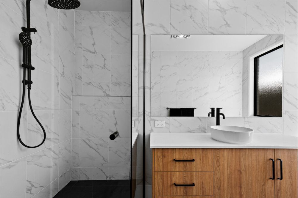 A Bathroom with A Sink , Shower and Mirror — Peter Betros Homes in Highfields, QLD