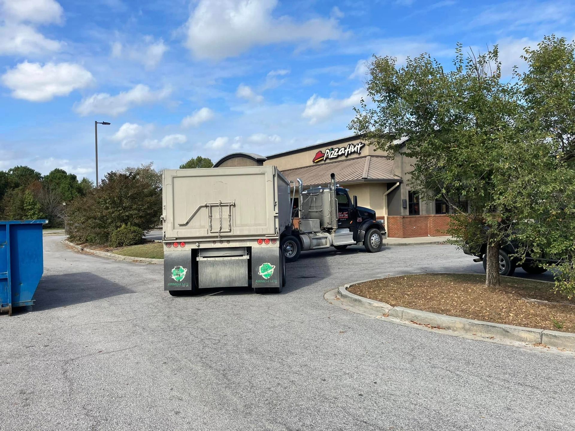 A garbage truck is parked in front of a building