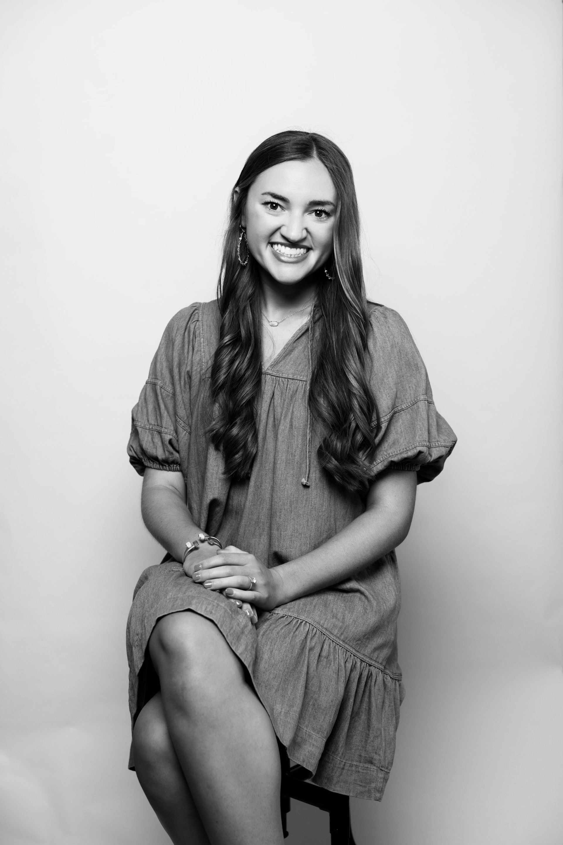 A black and white photo of a woman sitting on a chair.