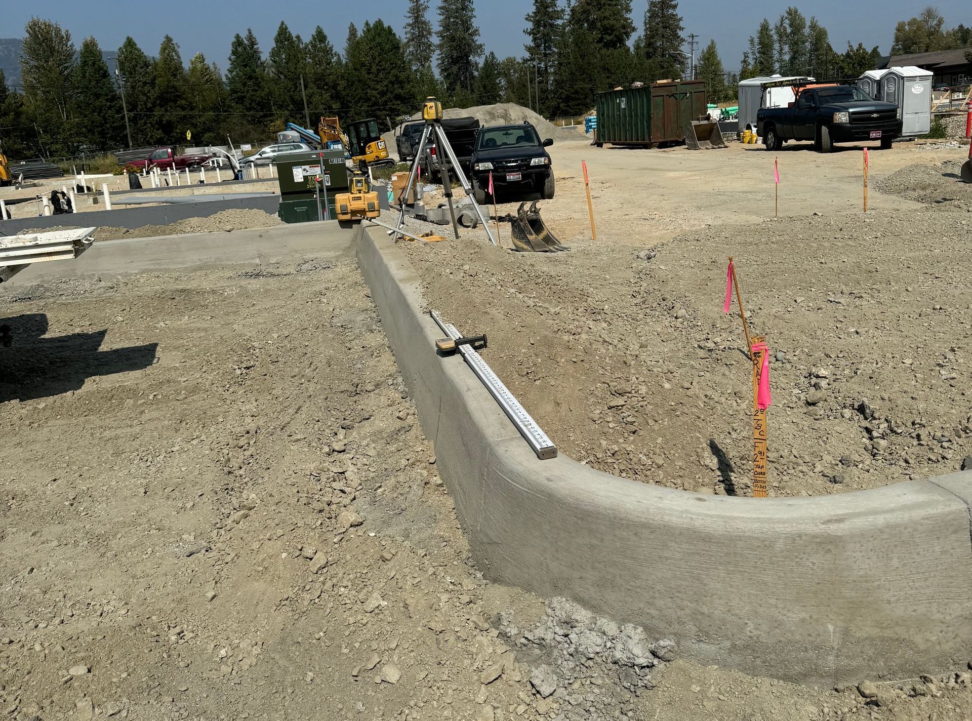 A concrete curb is being built on a dirt road. Done by Raise the Bar Construction