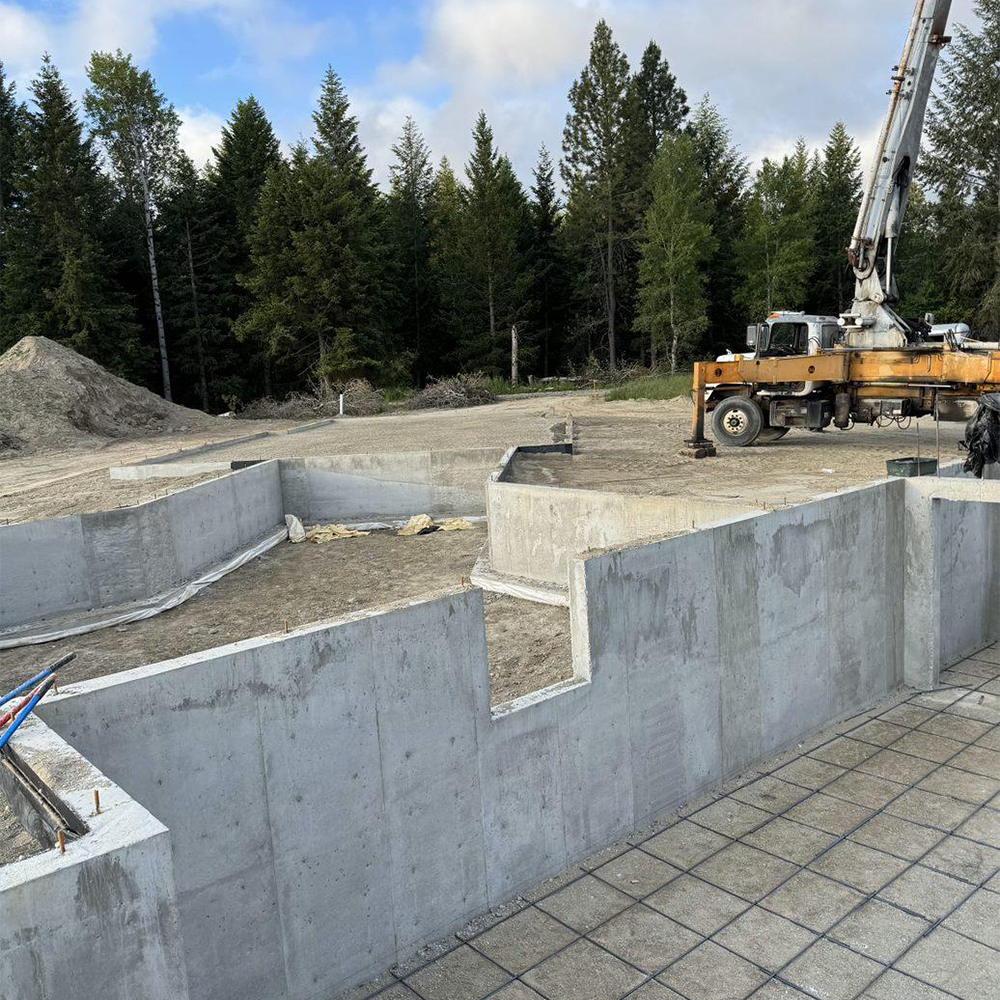 An aerial view of a construction site with a truck pumping concrete. Done by Raise the Bar Construction