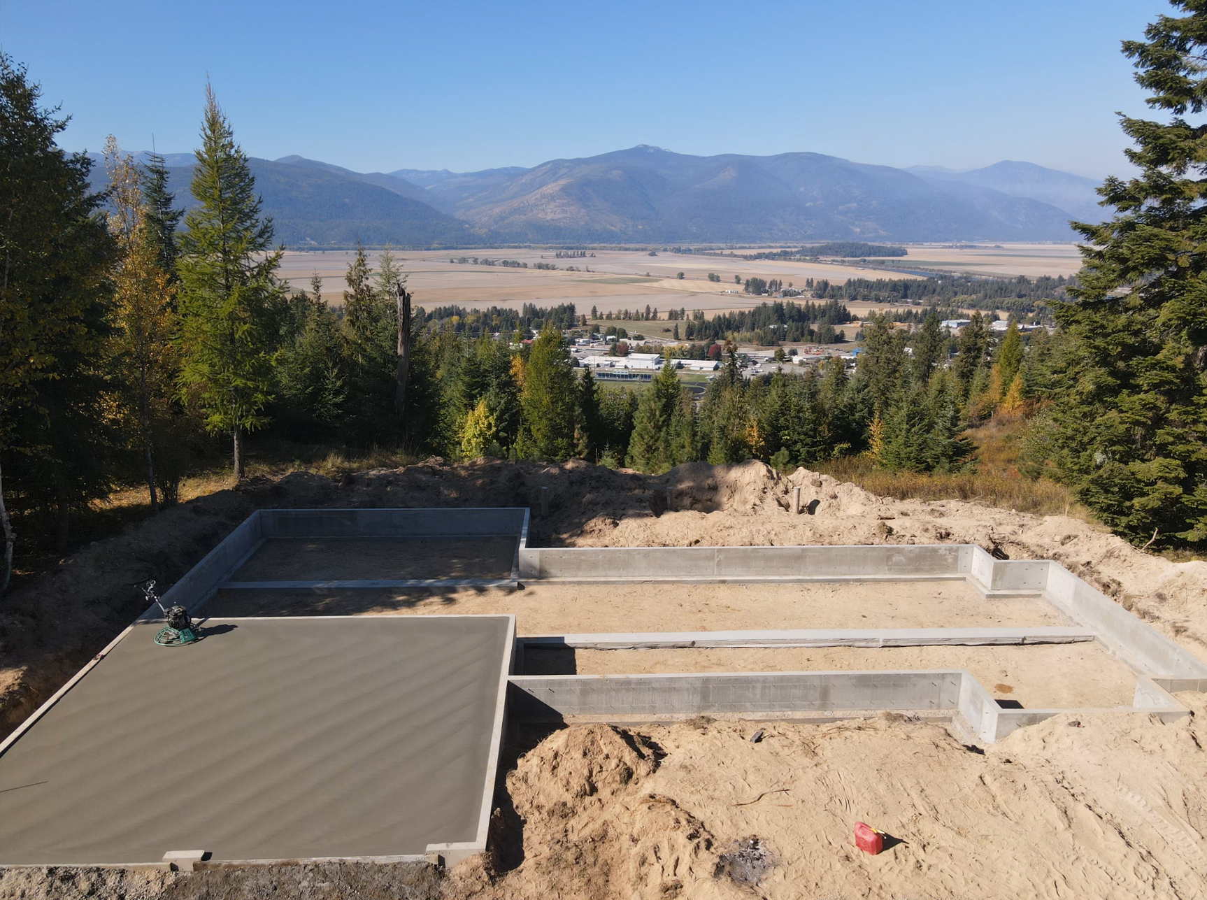 An aerial view of a construction site with mountains in the background. Project done by Raise the Bar Construction