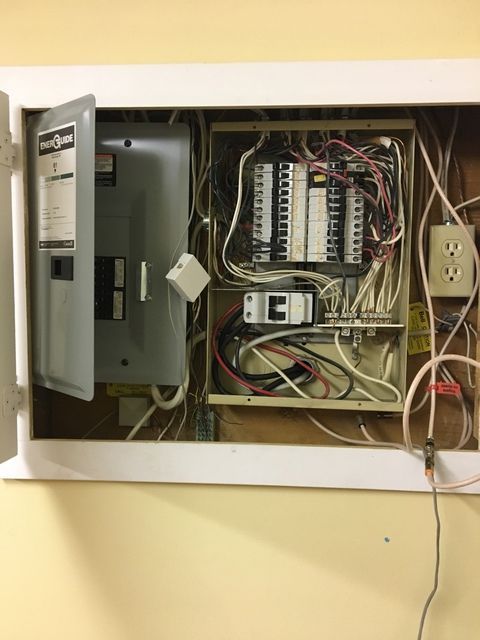 An open electrical box with a lot of wires coming out of it.