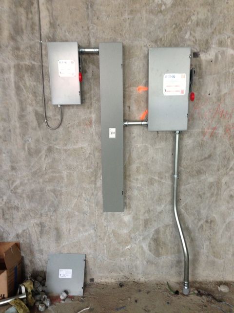 A couple of electrical boxes hanging on a wall