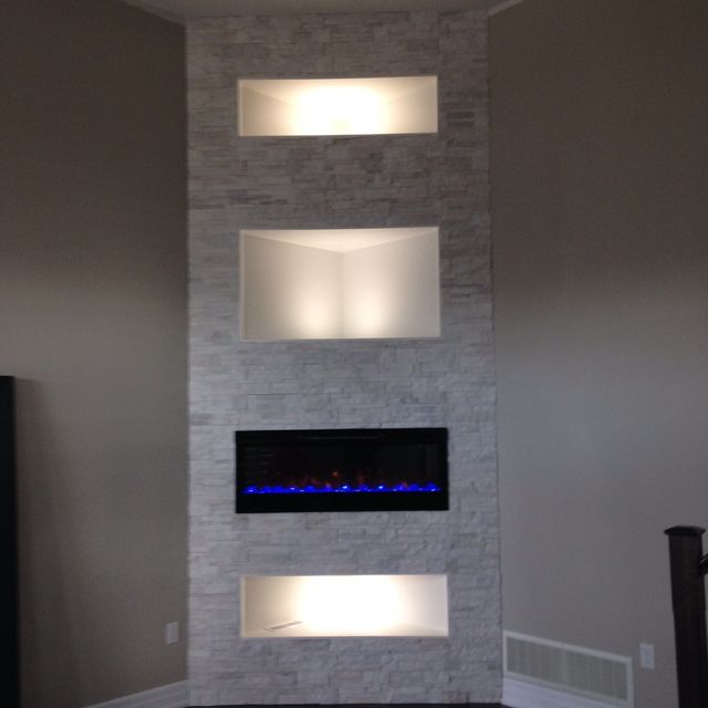 A living room with a fireplace and three shelves