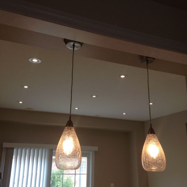 Two pendant lights are hanging from the ceiling in a room