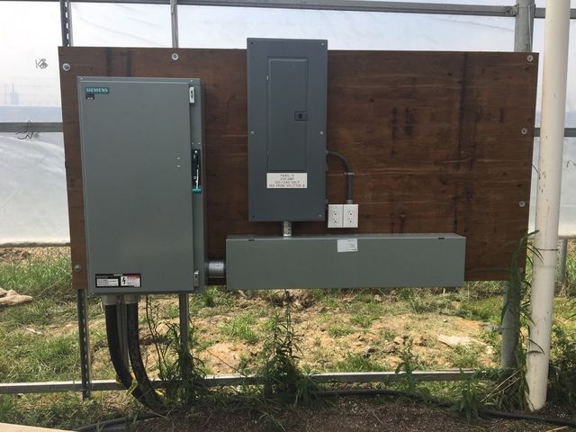 A electrical box is sitting on top of a wooden board.