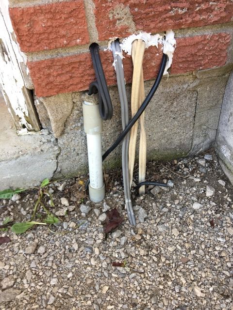 A brick wall with electrical wires coming out of it